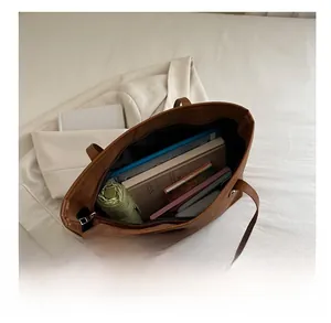 Internal view of large brown tote bag showing spacious capacity and secure top zipper