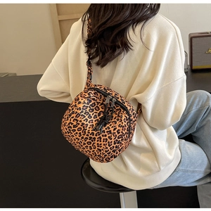 Detail of leopard print crossbody bag with double zippers and black braided pulls