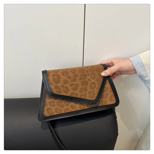 Detail of vintage leopard print crossbody bag featuring brown suede and black leather trim