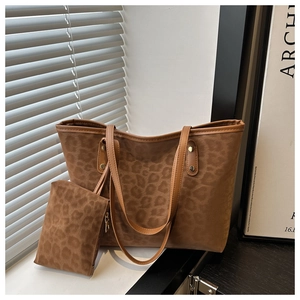 Detailed view of leopard print tote bag set with matching pouch and metal rivet accents
