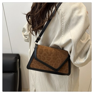 Detail of a vintage leopard print shoulder bag with black leather trim and gold buckle