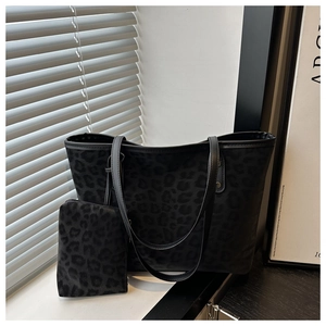 Detail view of leopard print tote bag with matching pouch and black leather straps