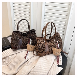 Detail of leopard print canvas tote bags with PU leather trim and plush bear charm