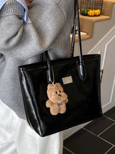 Glossy black French retro tote bag with long straps and a cute brown plush bear charm