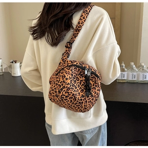Detail of trendy leopard print crossbody canvas bag with adjustable black strap on model
