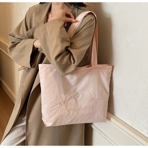 Detail view of the embroidered heart and star pattern on this pink tote bag for women
