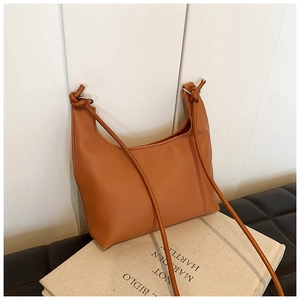 Detail of vintage brown PU leather hobo bag showing litchi texture and knotted strap