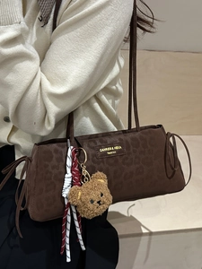Brown leopard embossed underarm bag with drawstring side and plush bear charm