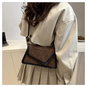 Fashionable leopard print crossbody bag with asymmetric flap styled with beige trench coat