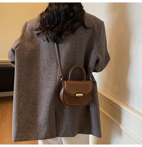 Detail of vintage brown leather saddle bag shown on model for realistic size and fit