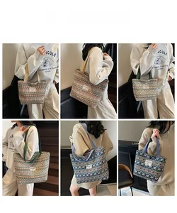 Ethnic style tote bag with geometric patterns and multiple color straps shown on model