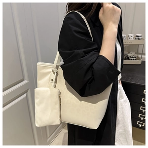Close-up of cream white leather tote bag featuring a practical detachable pouch detail
