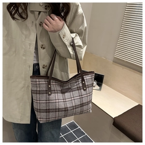 Detail showing vintage plaid pattern tote bag with brown leather strap and metal rivets