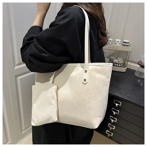 White minimalist faux leather tote bag set featuring a matching small zip pouch and gold hardware