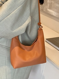 Chic orange hobo shoulder bag in soft pebbled leather with stylish knotted strap detail