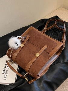 Brown leather and suede patchwork shoulder bag with gold hardware and plush charm decoration