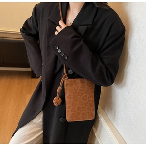 Detail of leopard print crossbody bag with unique knot decoration on the shoulder strap