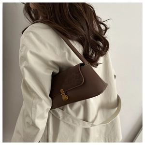 Rear view of a model wearing a brown leopard print shoulder bag with a gold metal clasp