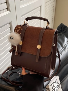 Retro brown leather backpack for women with dual strap buckles and plush pendant