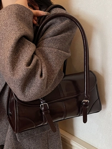 Deep brown patent leather underarm bag with double buckle straps in retro college style