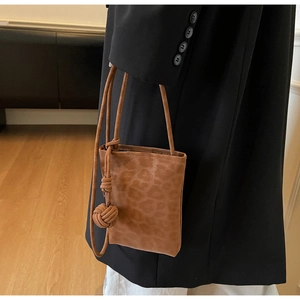 Detail of leopard print phone bag featuring unique handcrafted knot on the shoulder strap
