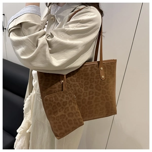 Detail of leopard print tote bag with small zippered pouch and long leather strap