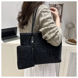Leopard print tote bag with small matching pouch shown in a stylish minimalist setting