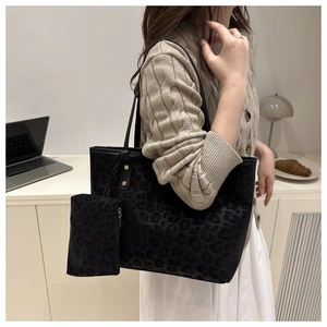 Close-up of leopard print tote bag with matching zippered pouch and sleek black shoulder straps