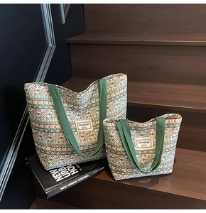 Detail of two-piece ethnic tote bags set with geometric patterns on wooden stairs