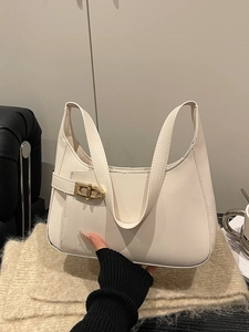Minimalist beige underarm bag with gold twist lock buckle and sleek crescent silhouette