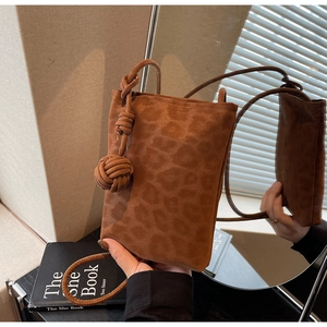 Close-up of leopard print crossbody phone bag with knot strap detail in suede