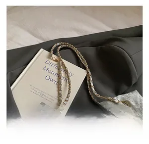 Detailansicht der silbernen Stepptasche mit Metallkette auf dunklem Blazer