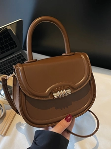 Classic dark brown leather saddle bag with gold metal hardware and adjustable strap