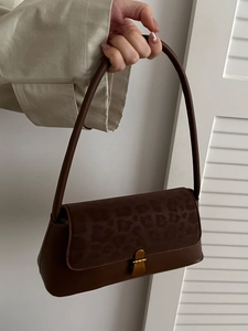 Vintage brown shoulder bag with leopard print flap and gold buckle in a minimalist style