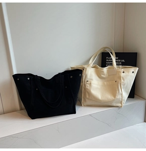 Detailed texture of black and white corduroy tote bags with metal studs on white steps
