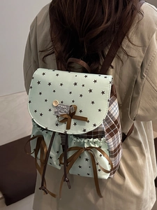 Mint green star pattern backpack with bow and plaid pockets worn by model