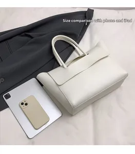 Comparación de tamaño del bolso tote blanco con iPad y móvil mostrando gran capacidad