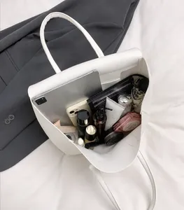 Vista detallada del interior de un bolso tote blanco con gran capacidad para tablet y móvil