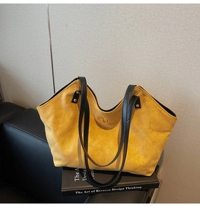 Macro view of yellow quilted tote bag featuring a gold twist lock and leather handle