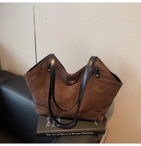 Close-up of brown quilted tote bag with suede texture and gold turn-lock closure