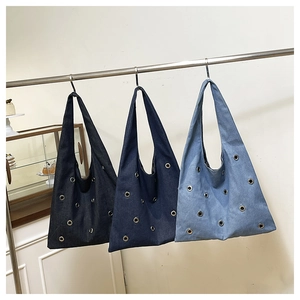 Détail de sacs cabas en denim rivetés en bleu foncé, indigo et nuances de bleu clair