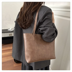 Bruine shopper met Fashion Bags-gravure op de schouder gedragen in een gezellig huis