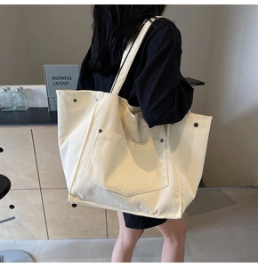 Detail of cream corduroy tote bag showing large capacity and metal rivet accents