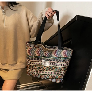 Detail of bohemian woven tote bag showing colorful geometric patterns and fabric label