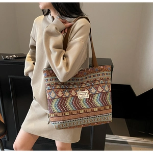 Detailed close-up of a large ethnic tote bag with geometric woven texture and shoulder strap