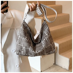 Detailed close-up of woven canvas tote bag with ethnic pattern wide strap and silver hardware
