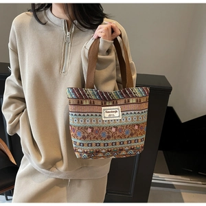 Detail of vintage woven tote bag featuring colorful geometric patterns and cotton handles