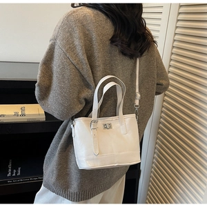 Détail du sac fourre-tout blanc avec fermoir rotatif en métal et bandoulière réglable