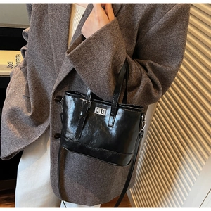 Détail du sac bandoulière en cuir verni noir avec boucle argentée et rabat vintage