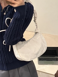 Chic white crescent shoulder bag with pleated texture and stylish scrunchie-style strap